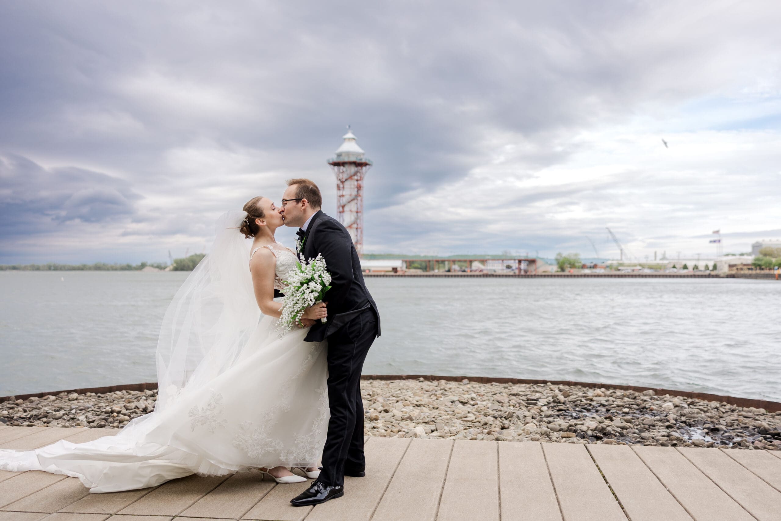 image of a bride and groom on the water front kissing