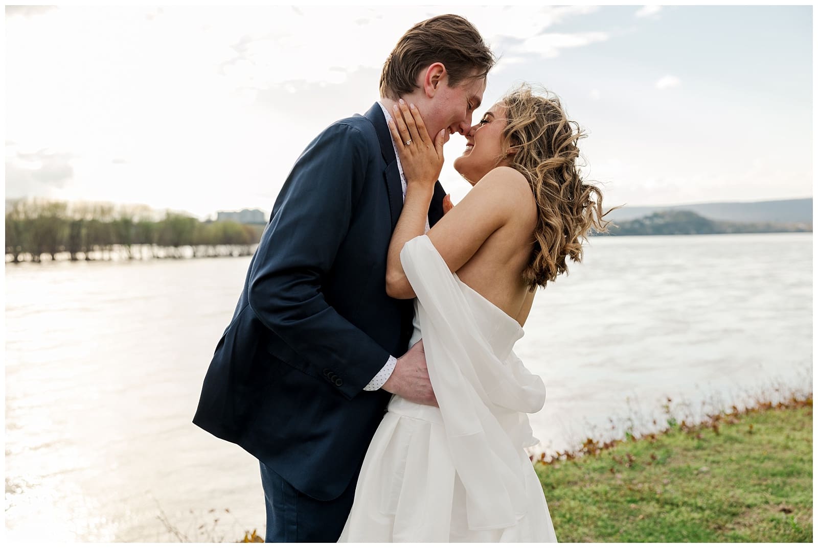 a couple sharing a kiss by the water during sunset