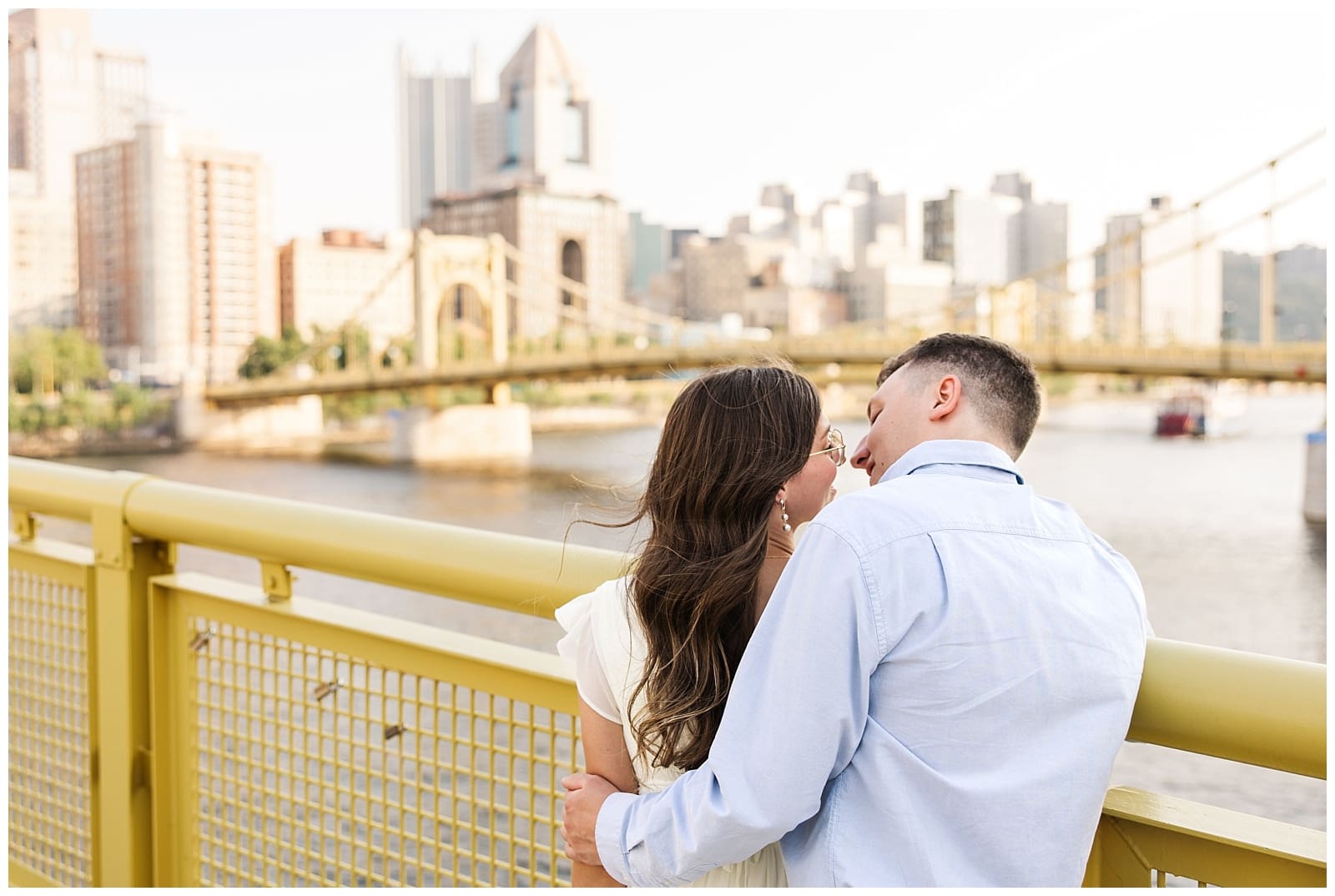 an image of a couple looking out over a bridge towards the city