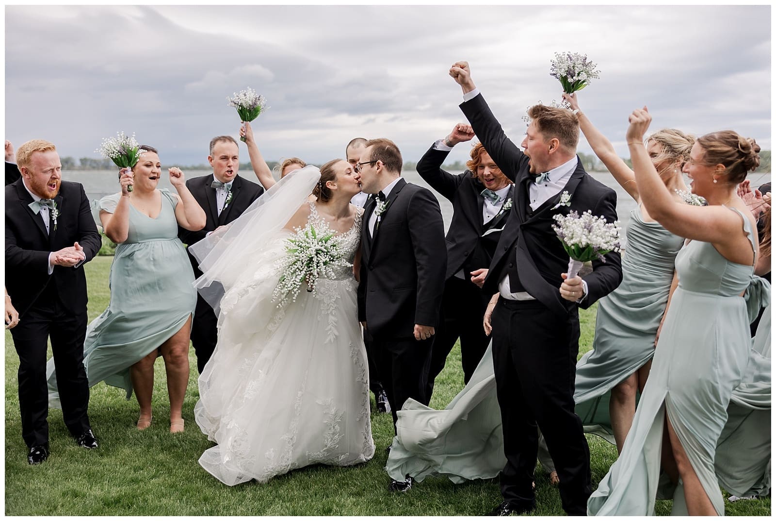 a wedding image of the bridal party cheering for the bride and groom